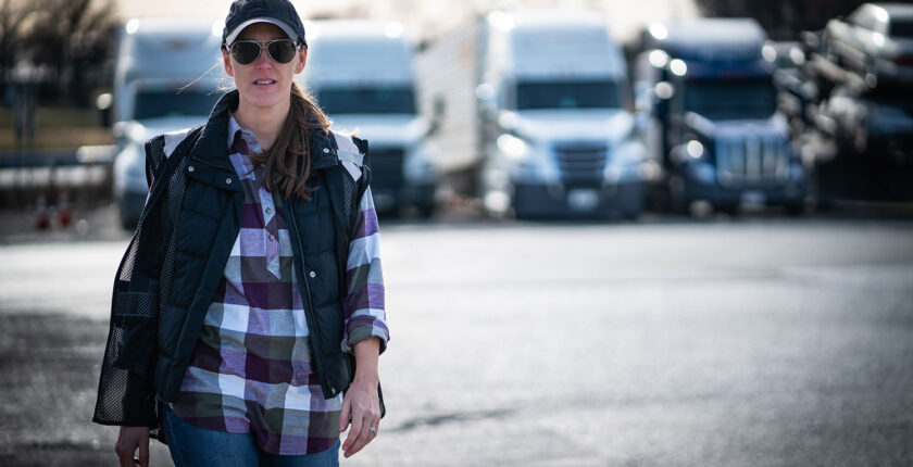 Woman commercial truck driver walking in trucking yard