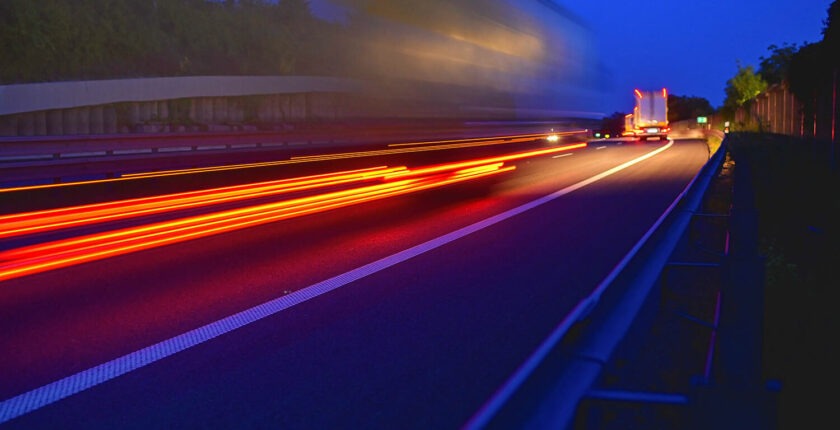 Highway traffic - motion blurred truck on a highway motorway speedway at dusk