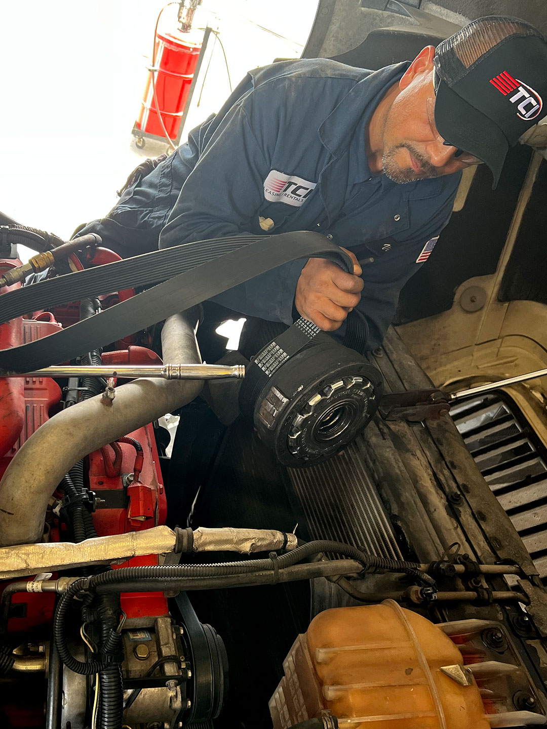 Technician working on truck engine in maintenance bay