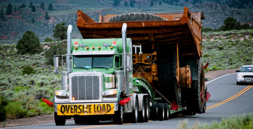 Semi pulling an oversized load of a super giant dump truck