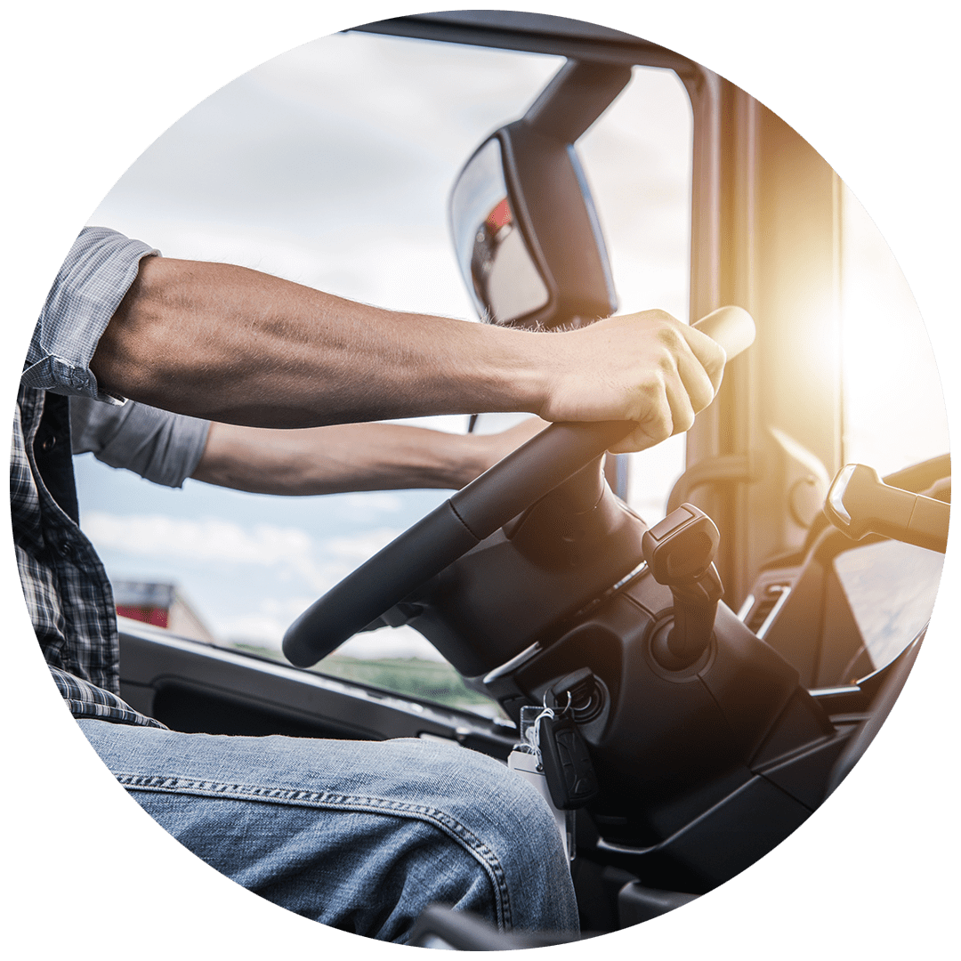 Close-up of man holding steering wheel in cab of truck