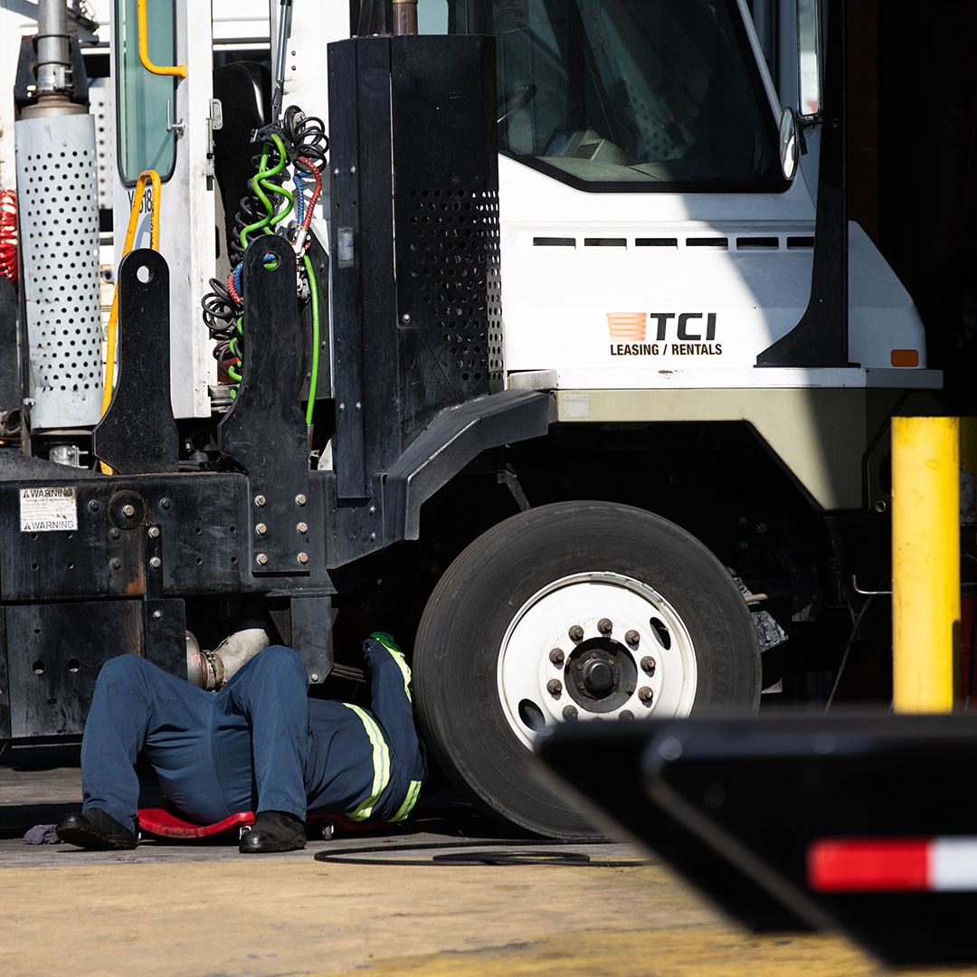 Mechanic on his back working underneath a truck