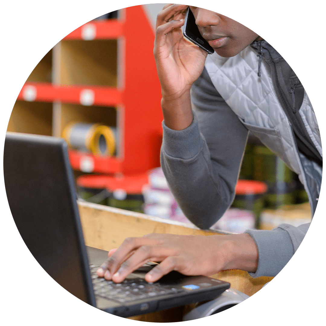 Closeup of man in warehouse working on laptop